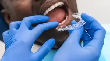 Dental hygienist fitting a clear retainer
